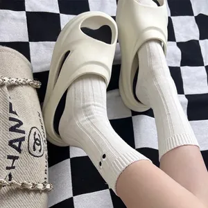 Cream white platform cutout slippers made of lightweight EVA material on a grid floor