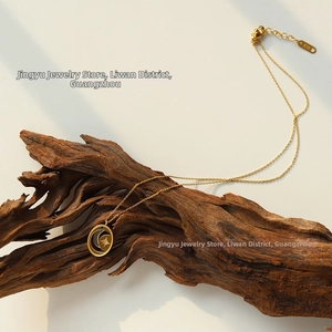 Close-up of gold moon and star pendant with K18 tag on textured wood background