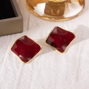 Detail view of burgundy irregular geometric stud earring with elegant gold plating
