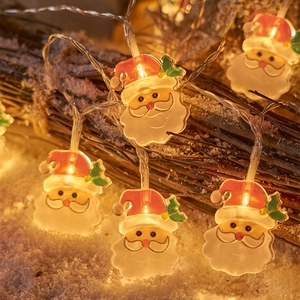 Festive LED string lights with Santa Claus figures on wood branches with artificial snow