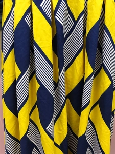 Detail von bedrucktem Stoff mit gelben, blauen und gestreiften geometrischen Mustern