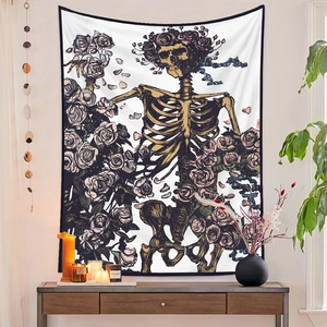 Detail of bohemian tapestry featuring a skull and rose illustration with gold accents