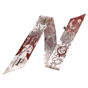 Detail of tan floral silk twilly scarf with elegant letter F print and bird patterns