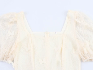 Detail of square neckline with 3D butterfly appliques on apricot lace puff sleeve top
