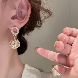 Elegant gold grid earrings with pearls and rhinestones shown on a female model