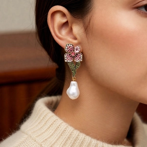 Boucles d'oreilles fleurs en cristal et perles baroques portées par un mannequin