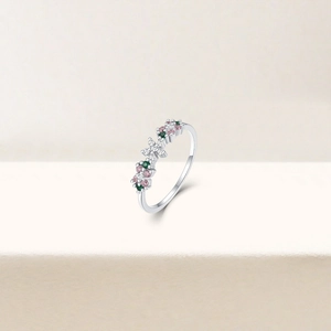 Macro detail of silver ring featuring floral design with pink and green zircon stones