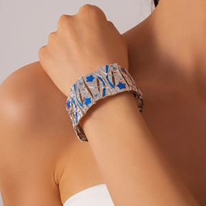 Detail of silver textured wide cuff bracelet with blue enamel stars and blue rhinestones
