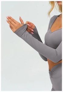 Détail d'un haut de yoga gris à manches longues avec passe-pouces et tissu élastique