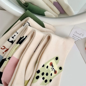 Detail of cream cotton socks featuring cute animal patterns and colorful accents