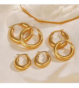 Dettaglio di tre misure di orecchini a cerchio placcati in oro 18K su seta chiara