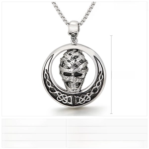Macro detail of gothic mummy skull pendant with angel wings in polished stainless steel