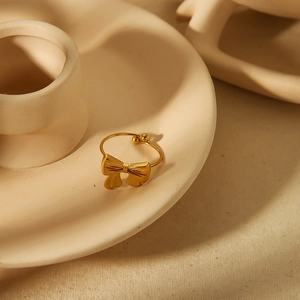 Elegant 18k gold plated stainless steel open ring with bowknot design on ceramic stand