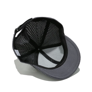 Detail view of grey breathable mesh baseball cap with 100 percent cotton washing label