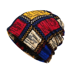 Detail of multi-color patchwork beanie showing knitted texture and black wave pattern