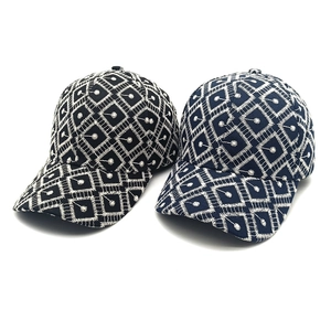 Black and navy baseball caps with white geometric embroidery on a clean white background