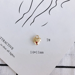 Detail view of 14x11mm gold heart cross pendant with pearl inlay for jewelry making