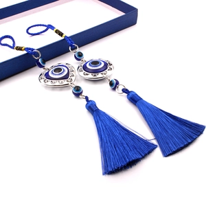 Detail of blue evil eye car charms with heart and round silver frames and blue tassels
