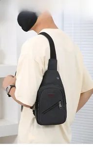 Detailed view of black canvas sling bag with SPORT leather patch and zip pockets