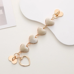 Detail of plush beige heart charms on a gold zinc alloy chain for mobile phone cases