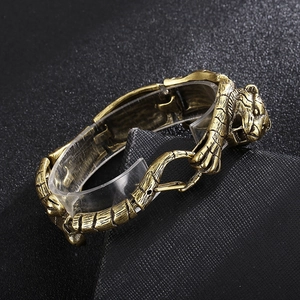 Detailed close-up of tiger head carving on antique gold men's stainless steel bracelet