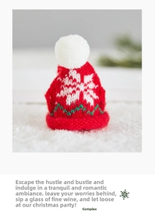 Mini red knit Christmas hat with white snowflake pattern and pom-pom on faux snow