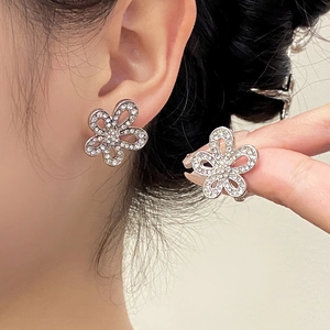 Close-up of elegant flower stud earrings featuring shimmering crystals on a silver base