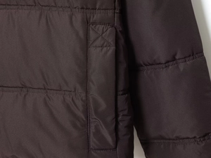 Close-up of horizontal quilting and side pocket detail on a warm hooded jacket