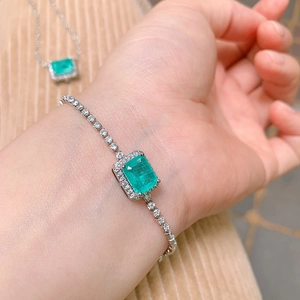 Close-up of elegant silver bracelet with square green gemstone and sparkling zircons