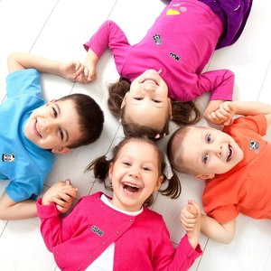 Colorful cow embroidery patches on kids clothing with children lying in a circle
