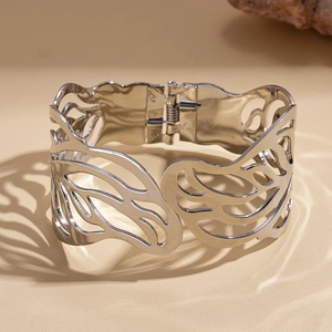 Detail of silver openwork hinge bracelet with butterfly wing patterns and polished finish