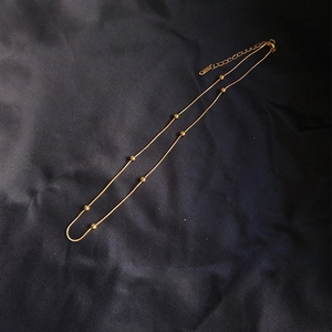 Elegant 18K gold plated stainless steel snake chain necklace with beads on silk fabric