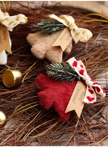 Detail of plush Christmas tree ornaments with metal bells and Merry Christmas tags