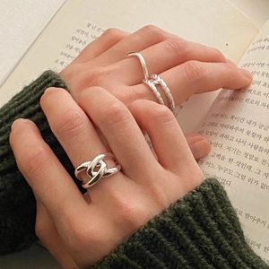 Detail of 925 sterling silver rings with hollow chain and twisted design on a model's hand