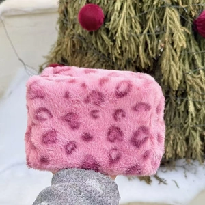 Detailed close-up of pink leopard print faux fur makeup bag with soft plush texture