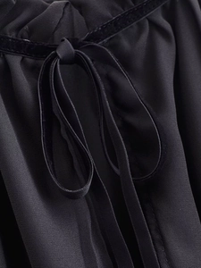 Detail shot of black bow tie neckline and pleated texture on French chic women blouse