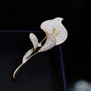 Macro shot of elegant calla lily crystal brooch with gold finish on jewelry box