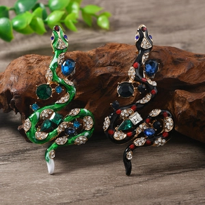 Detail of vintage snake brooches with colorful enamel, rhinestones and large gemstones
