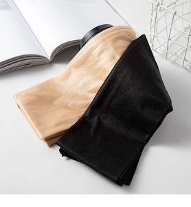 Glossy ultra-thin sheer pantyhose in black and skin tones shown on a lifestyle table