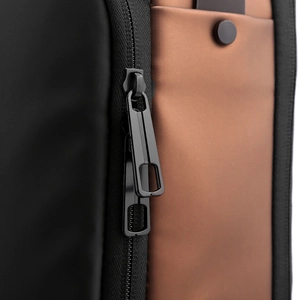 Detail of dual metal zippers on black and brown water-resistant crossbody chest bag