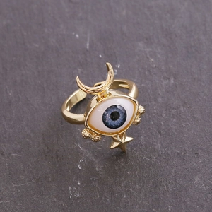 Close-up of 18K gold eye ring with blue devil eye, moon and star details on rock
