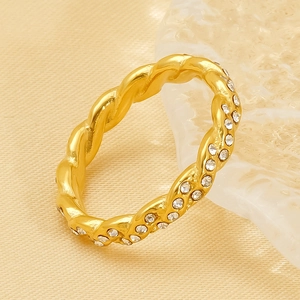 Elegant gold twisted rope ring with crystals shown from a 45-degree angle on silk