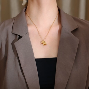 Detailed close-up of a golden origami elephant pendant on a stainless steel chain