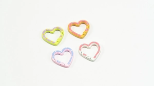 Detail of colorful polka dot heart-shaped spring ring carabiners in macaron colors