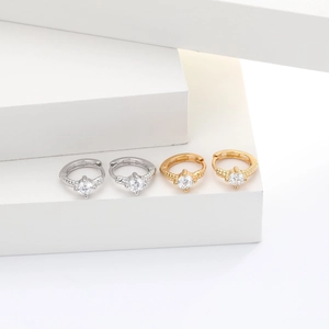 Macro detail of gold and silver S925 sterling silver hoop earrings with zircon on white steps