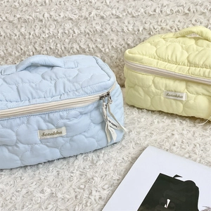 Detailed view of quilted cloud texture storage bags with soft fabric and ribbon zip