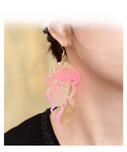 Close-up of creative pink jellyfish earrings with sparkling gold glitter detail on model