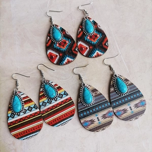 Detail of bohemian turquoise drop earrings with vibrant geometric patterned wood inlays