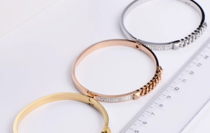 Detailed view of three-color titanium steel bangles with cubic zirconia and Cuban link texture