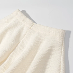 Détail de la jupe en tweed blanc avec tissu texturé et fermeture éclair invisible